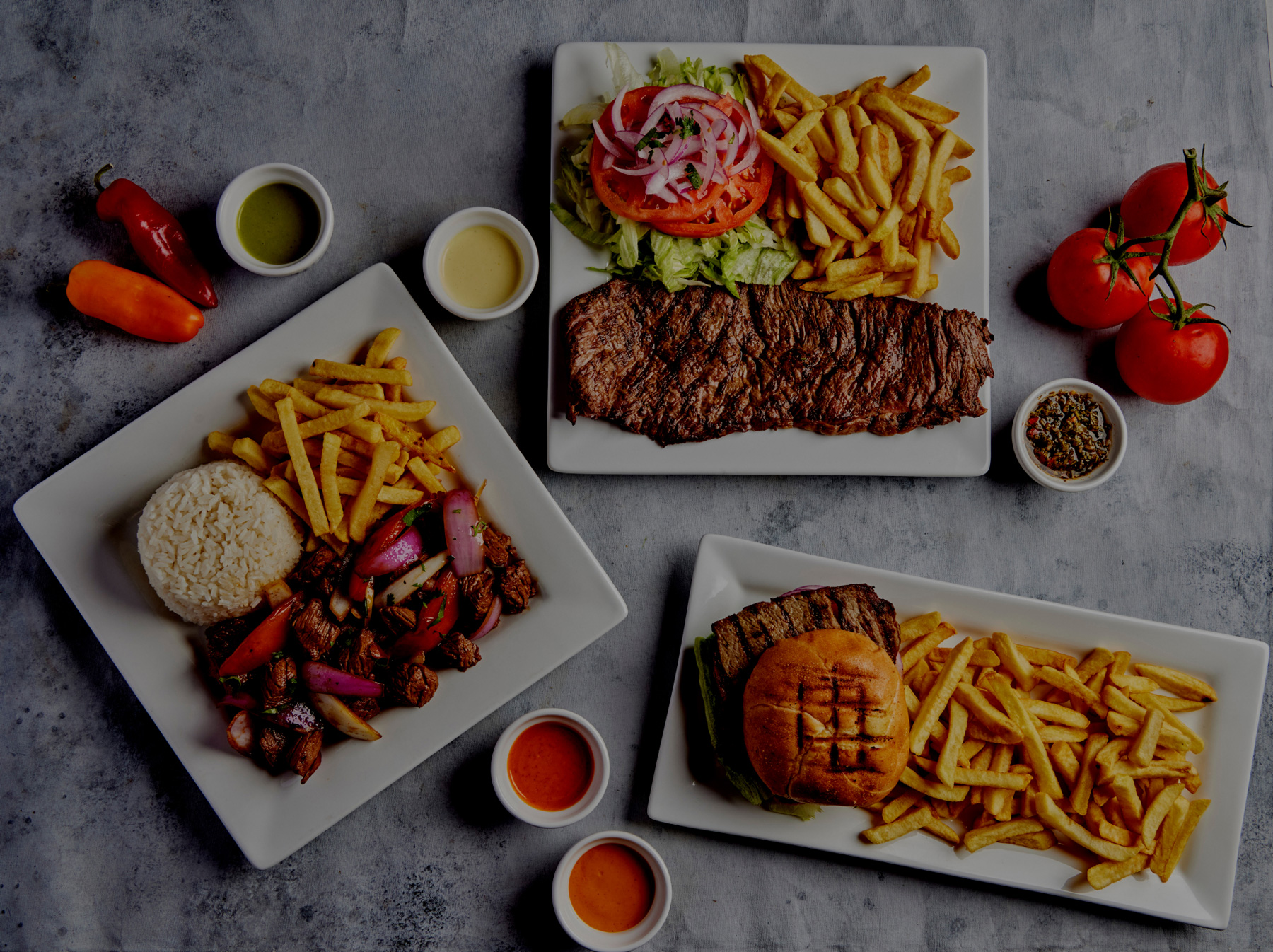 Plates of food and sauces. Grilled beef, beef sauteed, sandwich, fries salad, and rice