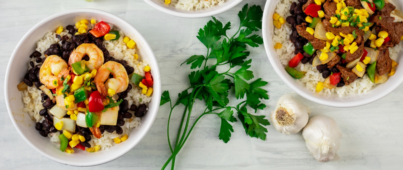 Seafood and beef rice bowls. With vegetables, garlic, and cilantro.